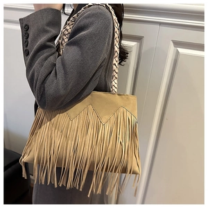 Detail showing long suede tassels and braided strap of the khaki shoulder bag