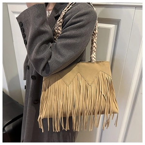 Detail of khaki suede bucket bag featuring long fringe and woven braided shoulder strap