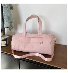 Pink nylon duffel bag for fitness and travel with adjustable shoulder strap and hand grips