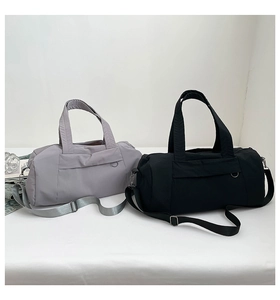 Detail view of large nylon duffel bags in black and grey with adjustable shoulder straps