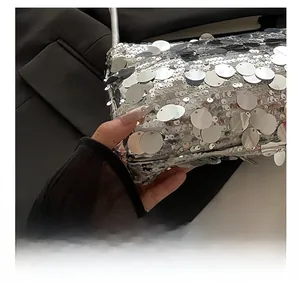 Gros plan sur les paillettes argentées et coutures précises de ce sac de soirée chic