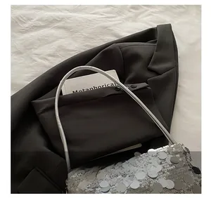 Détail du sac à bandoulière à paillettes argentées avec texture en écailles et sangle