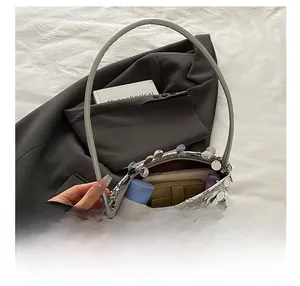 Sac bandoulière pailleté argenté montrant l'espace pour téléphone et maquillage