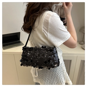 Détail d'un sac à épaule à paillettes noires avec de grandes paillettes rondes et chics