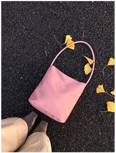 Pink nylon tote bag with Hope and Future text on autumn asphalt with ginkgo leaves