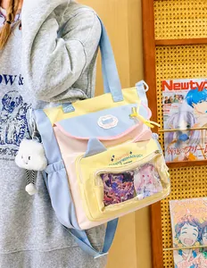 Detail of macaron nylon messenger bag with transparent PVC window and plush cloud charm