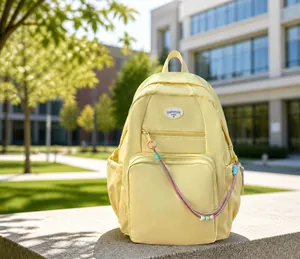 Dettaglio dello zaino in nylon giallo con tasche trasparenti e catena di perline colorate