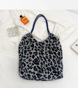 Detail of plush leopard print tote bag with durable blue and white woven handles
