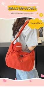 Détail du sac à bandoulière en nylon rouge avec porte-monnaie et cordon réglable