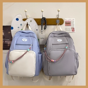 Vista dettagliata di zaini eleganti e dolci con tasche trasparenti e ciondoli decorativi