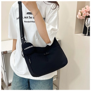 Détail d'un sac bandoulière en nylon noir avec sangle réglable et petite pochette