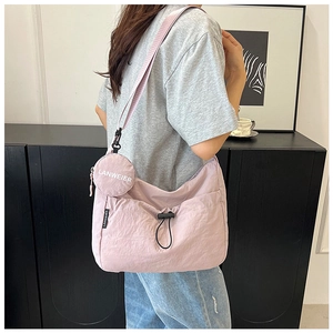 Détail du sac à bandoulière en nylon violet clair avec son petit porte-monnaie rond