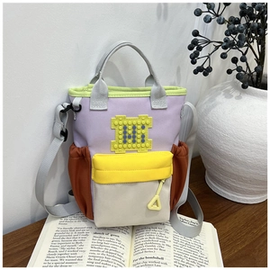 Detailed view of colorful canvas bucket bag with patchwork design and utility pockets