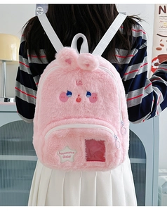 Detalle de una mini mochila de felpa rosa con orejas de conejo y ventana clara