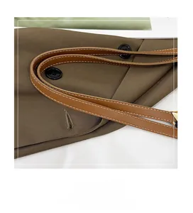 Détail du sac cabas marron montrant les surpiqûres contrastées et le gros bouton déco