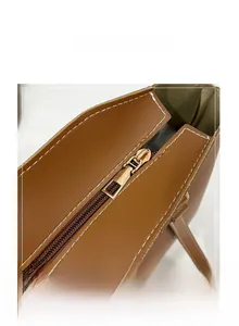 Détail de la fermeture éclair dorée et coutures blanches sur le sac fourre-tout