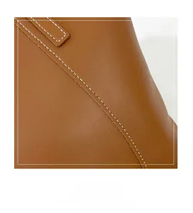 Détail de couture blanche contrastée sur un sac cabas en cuir marron de haute qualité
