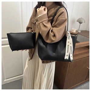 Detail view of black vintage tote bag set with branded letter ribbon and inner pouch