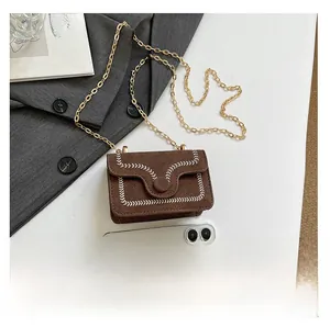 Detailansicht der mini dunkelbraunen Wildledertasche mit Wellennaht und Goldkette