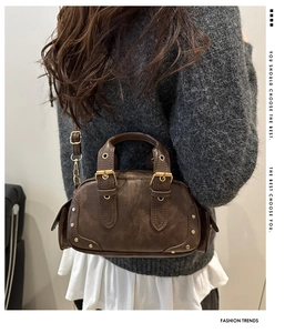Detail of vintage dark brown faux leather bowling bag with metallic studs and buckle straps