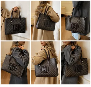Detailansicht der großen Shopper-Tasche mit M-Monogramm und Leder-Schultergurten