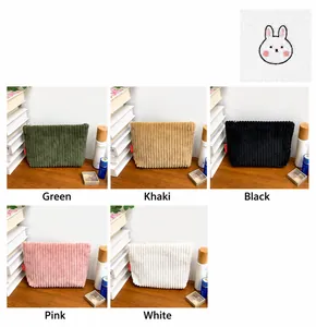 Gros plan détaillé de la texture du velours côtelé et broderie lapin sur la pochette