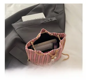 Vue intérieure d'un sac seau en tweed rose montrant sa capacité et sa bandoulière en chaîne