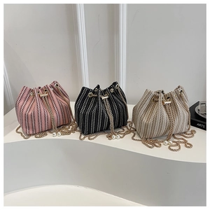 Détails des sacs seaux tissés avec cordons, chaînes dorées et breloques en perles