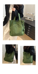 Detail van groene canvas tote tas met verstelbare schouderband en modieuze label