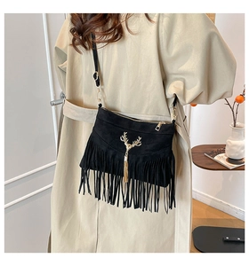 Detailansicht der schwarzen Wildledertasche mit goldener Hirschschnalle und Boho-Fransen