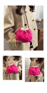 Detail of rose red quilted drawstring bucket bag with black bow embroidery