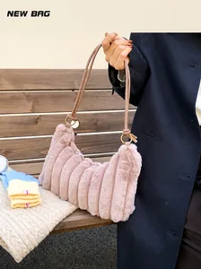 Detail of plush tie-dye shoulder bag with vertical pleats and golden metal ring hardware