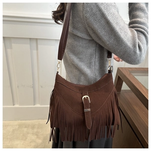 Dettaglio della borsa tote in pelle scamosciata marrone scuro con lunghe nappe e fibbia