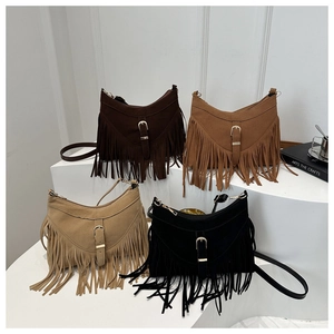 Fringe crossbody bags in four colors arranged on white stands in bohemian style