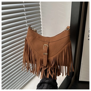 Detail of brown suede tote bag with fringe accents and a decorative metal buckle