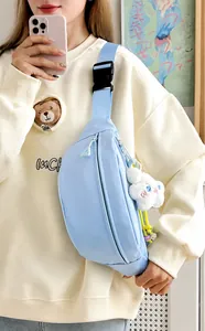 Detail of light blue nylon chest bag with adjustable strap and cloud plush pendant