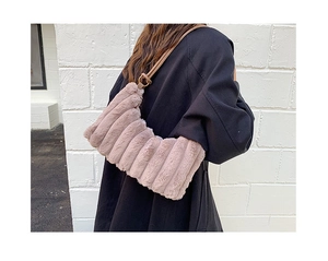 Close-up of light brown plush tote bag with vertical stripes and metallic rings