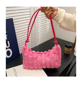 Detail of pink plush faux fur shoulder bag featuring striped quilting and slender straps
