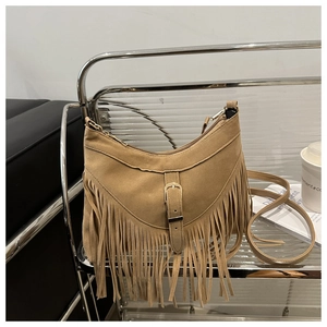 Dettaglio borsa bohémien in camoscio cammello con lunghe nappe e fibbia in metallo alla moda