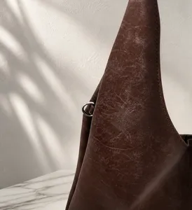 Close-up of vintage suede tote bag material and silver D-ring hardware detail