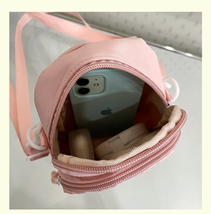 Internal view of pink canvas phone bag showing storage capacity for mobile and cosmetics