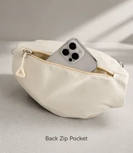 Close-up of secure back zipper pocket on off-white crossbody bag for phone storage