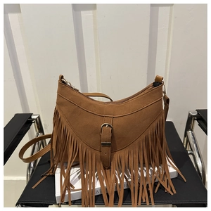 Dettaglio borsa a mezzaluna in camoscio marrone con frange e hardware dorato