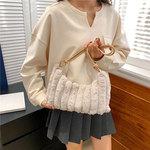 Detail of cream plush shoulder bag with pleated faux fur texture and leather strap