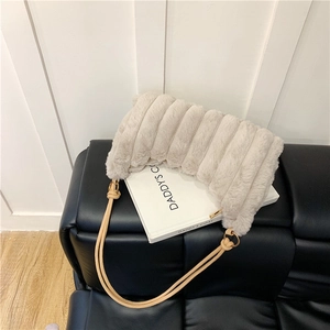 Detail of plush beige shoulder bag with thick stripe faux fur and gold ring straps