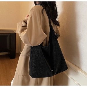Detail of minimalist black suede Hobo bag with VALISHI logo and metal ring knot