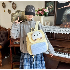 Detailansicht eines flauschigen Cartoon-Bären-Rucksacks in Gelb und Blau mit weicher Textur