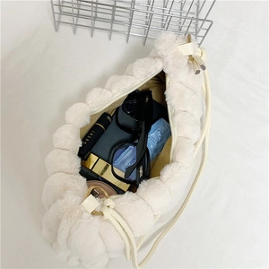 Top view of the spacious plush bag interior showing sunglasses and cosmetic items