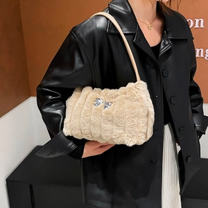 Detailansicht der beigen Plüschtasche mit pelziger Textur und silberner Schleifenverzierung