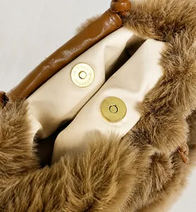 Detailed close-up of dark brown plush bag with a strong gold magnetic buckle closure